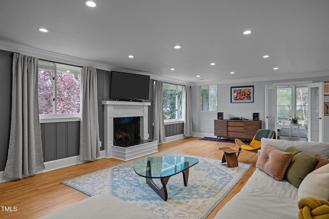 living room with recessed lighting, ornamental molding, light wood-style flooring, and plenty of natural light