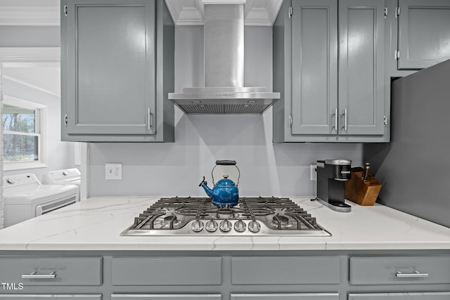 kitchen with crown molding, gray cabinetry, stainless steel gas stovetop, and wall chimney exhaust hood