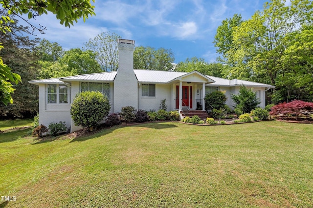 single story home featuring brick siding, a front lawn, and a chimney