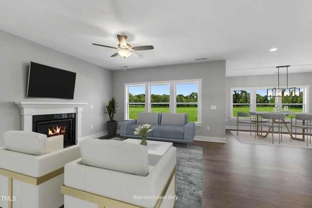 living area with recessed lighting, healthy amount of natural light, baseboards, a glass covered fireplace, and a ceiling fan