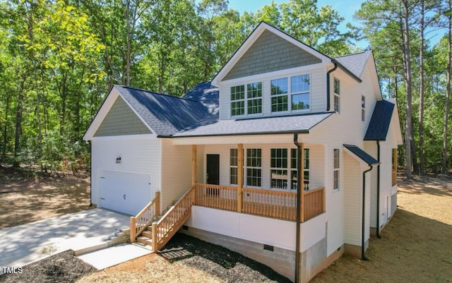 view of front of home with a shingled roof, a porch, a garage, and concrete driveway