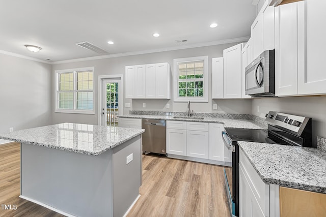 kitchen featuring a sink, visible vents, ornamental molding, and appliances with stainless steel finishes