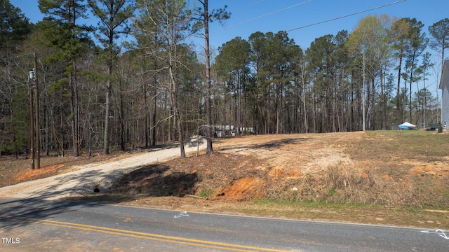 view of road featuring a wooded view