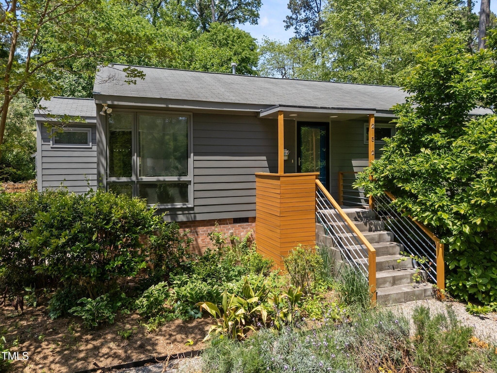 view of front of home with a shingled roof and stairway