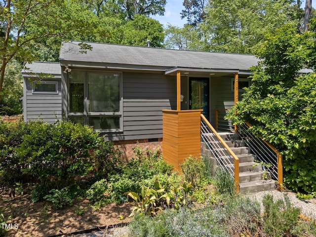 view of front of home with a shingled roof and stairway