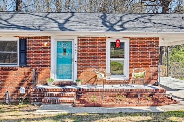 6407 Kimridge Rd, Fayetteville, NC 28314 - view of exterior entry featuring a carport, brick siding, and roof with shingles