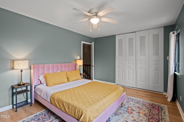 bedroom with a closet, baseboards, and light wood finished floors