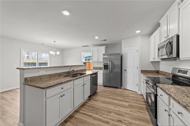 524 Mineral Spring Ln, Fuquay Varina, NC 27526 - kitchen featuring a chandelier, a kitchen island with sink, stainless steel appliances, a sink, and light wood-type flooring