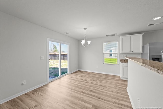 524 Mineral Spring Ln, Fuquay Varina, NC 27526 - unfurnished dining area with a chandelier, a healthy amount of sunlight, and light wood-style floors