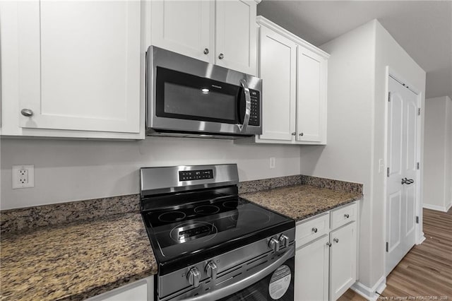524 Mineral Spring Ln, Fuquay Varina, NC 27526 - kitchen with white cabinetry, stainless steel appliances, baseboards, dark stone counters, and light wood-style flooring
