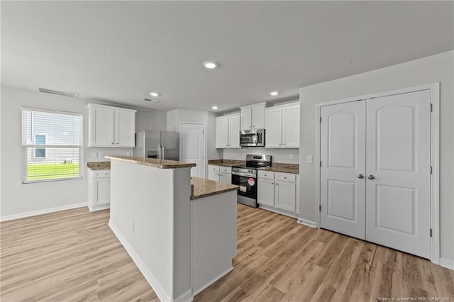 524 Mineral Spring Ln, Fuquay Varina, NC 27526 - kitchen featuring white cabinetry, a center island, light wood-type flooring, and appliances with stainless steel finishes