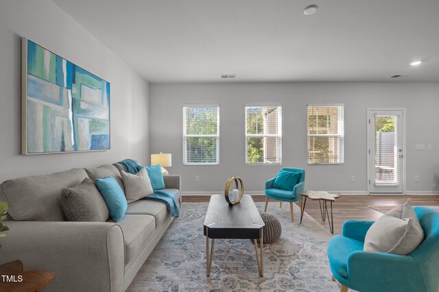living room with wood finished floors, baseboards, and recessed lighting