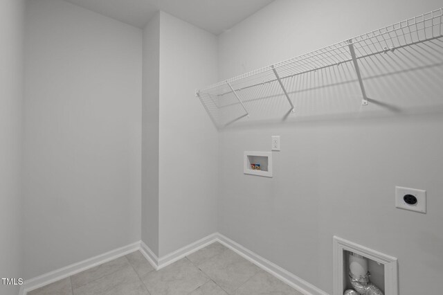 laundry area with electric dryer hookup, hookup for a washing machine, baseboards, and light tile patterned flooring
