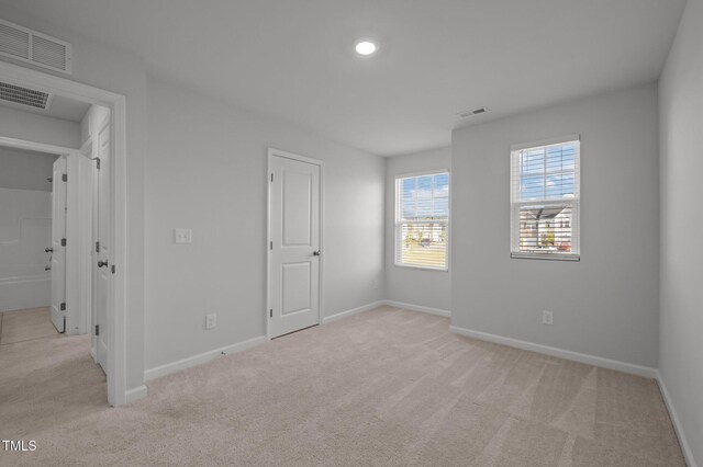 unfurnished bedroom featuring light colored carpet and baseboards