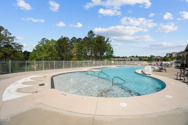 community pool with fence and a patio