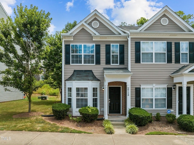 townhome / multi-family property with a front yard