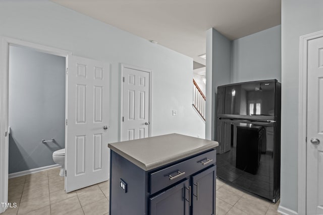 kitchen with baseboards, a center island, and light tile patterned flooring