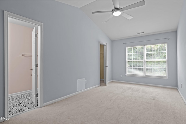 interior space featuring carpet floors, baseboards, vaulted ceiling, and a spacious closet