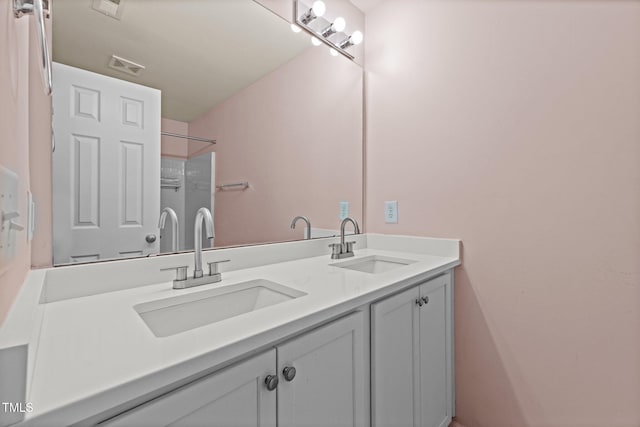 bathroom with visible vents, a sink, and double vanity