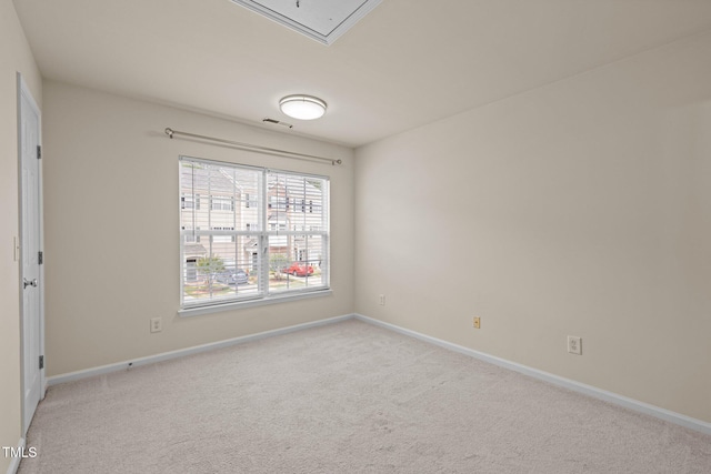 spare room with carpet floors, baseboards, attic access, and visible vents