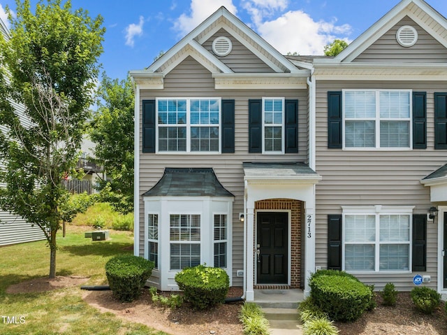 townhome / multi-family property with a front yard