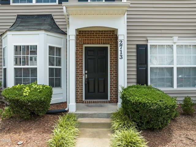 entrance to property featuring brick siding
