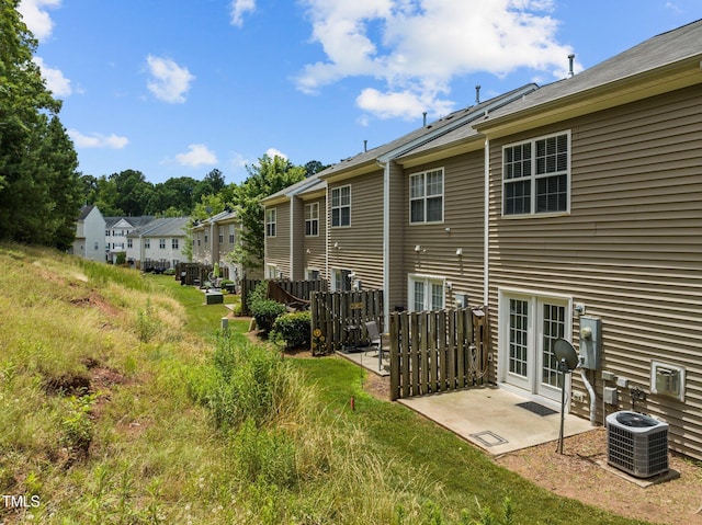 rear view of property featuring a patio, cooling unit, and a residential view