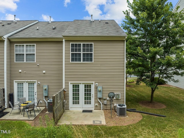 rear view of property featuring a lawn, central AC, a patio area, and french doors