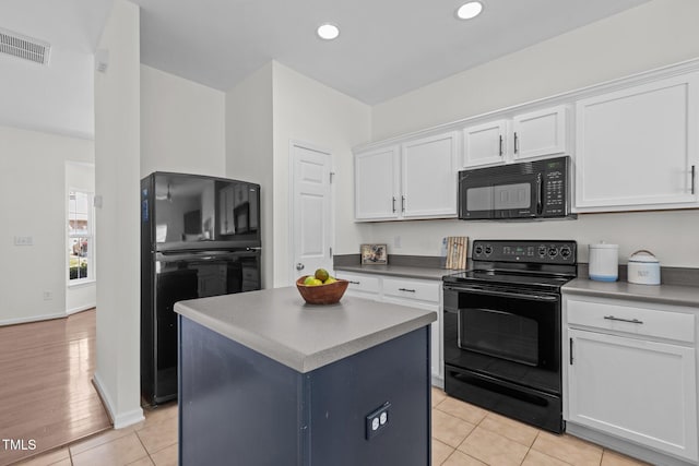 2713 Wyntercrest Ln, Durham, NC 27713 - kitchen with visible vents, a center island, white cabinets, light tile patterned floors, and black appliances
