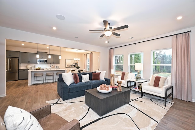 4867 Pioneer Dr, Sanford, NC 27330 - living room with light wood-type flooring, ceiling fan with notable chandelier, visible vents, and recessed lighting