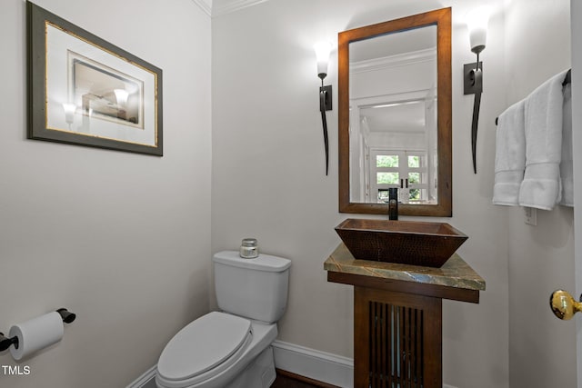 3915 Nottaway Rd, Durham, NC 27707 - half bathroom featuring toilet, a sink, baseboards, and crown molding