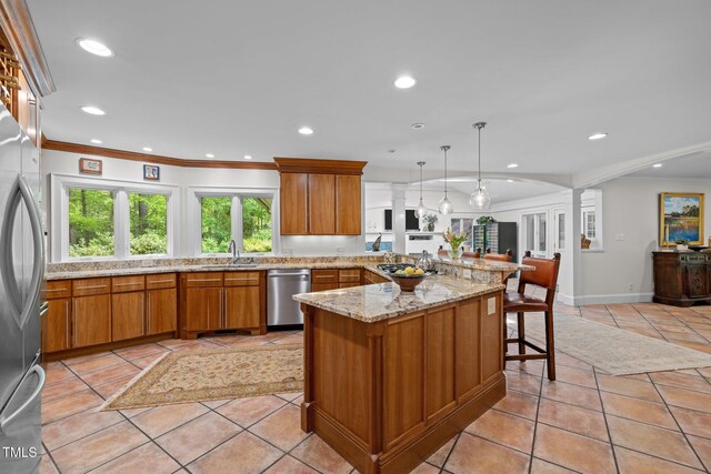 3915 Nottaway Rd, Durham, NC 27707 - kitchen featuring stainless steel appliances, a sink, brown cabinets, a peninsula, and ornamental molding
