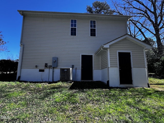 rear view of property with a lawn and central AC