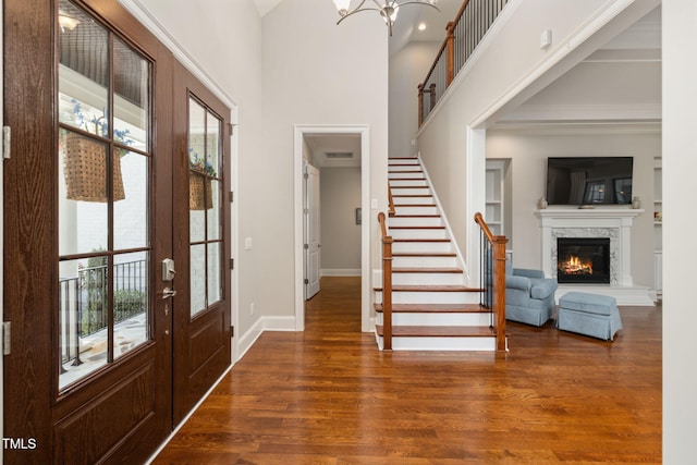 301 Rocking Ranch Ct, Cary, NC 27519 - foyer entrance with french doors, wood finished floors, a glass covered fireplace, a towering ceiling, and stairway