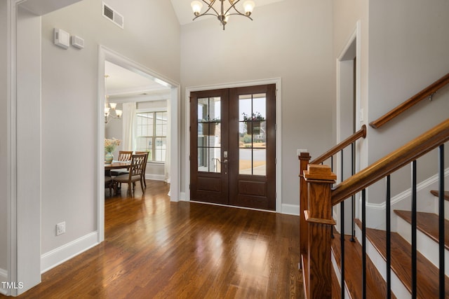 301 Rocking Ranch Ct, Cary, NC 27519 - foyer entrance featuring a chandelier, french doors, wood finished floors, stairway, and high vaulted ceiling