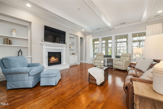301 Rocking Ranch Ct, Cary, NC 27519 - living room featuring wood finished floors, built in features, beamed ceiling, a glass covered fireplace, and crown molding