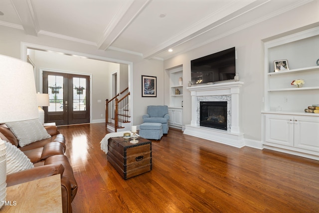 301 Rocking Ranch Ct, Cary, NC 27519 - living room featuring built in shelves, wood finished floors, beamed ceiling, ornamental molding, and a high end fireplace