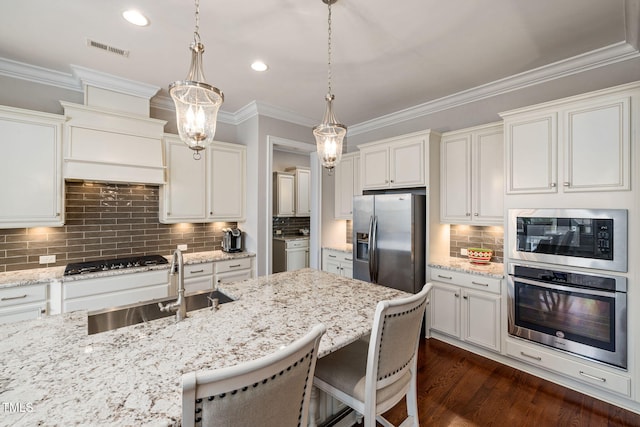 301 Rocking Ranch Ct, Cary, NC 27519 - kitchen with appliances with stainless steel finishes, backsplash, decorative light fixtures, a kitchen breakfast bar, and crown molding