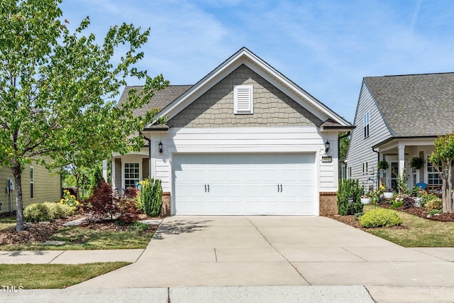 craftsman-style house featuring a garage, driveway, and brick siding