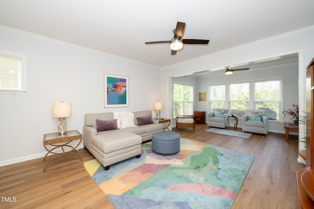 living room with crown molding, a ceiling fan, baseboards, and wood finished floors