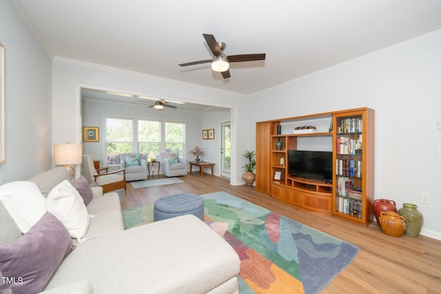 living area with crown molding, a ceiling fan, baseboards, and wood finished floors