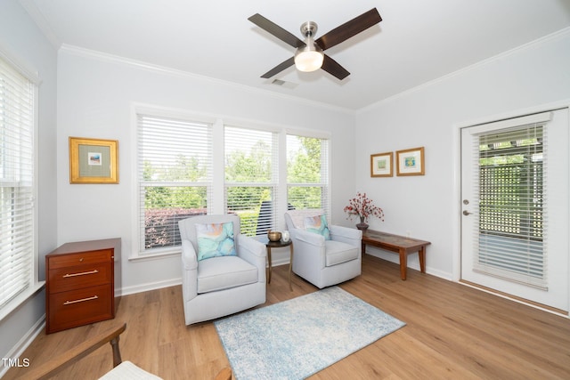 living area featuring crown molding, ceiling fan, and light wood-style floors