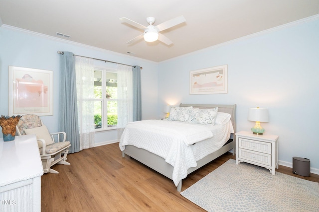 bedroom featuring crown molding, baseboards, visible vents, and light wood finished floors