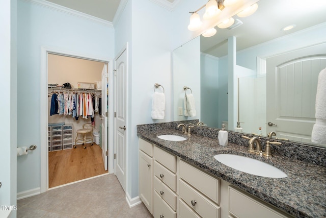 bathroom featuring a sink, tile patterned flooring, and ornamental molding
