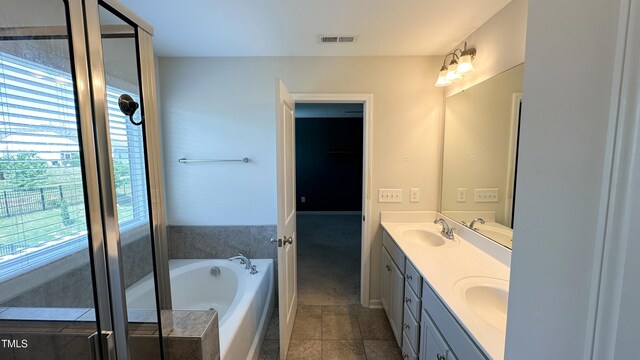 49 W Copenhaver Dr, Clayton, NC 27527 - bathroom with double vanity, a garden tub, and tile patterned flooring