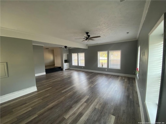 unfurnished living room featuring dark wood-style floors, baseboards, ceiling fan, a textured ceiling, and crown molding