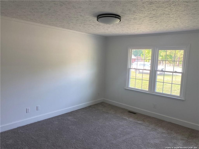 carpeted spare room with visible vents, a textured ceiling, and baseboards
