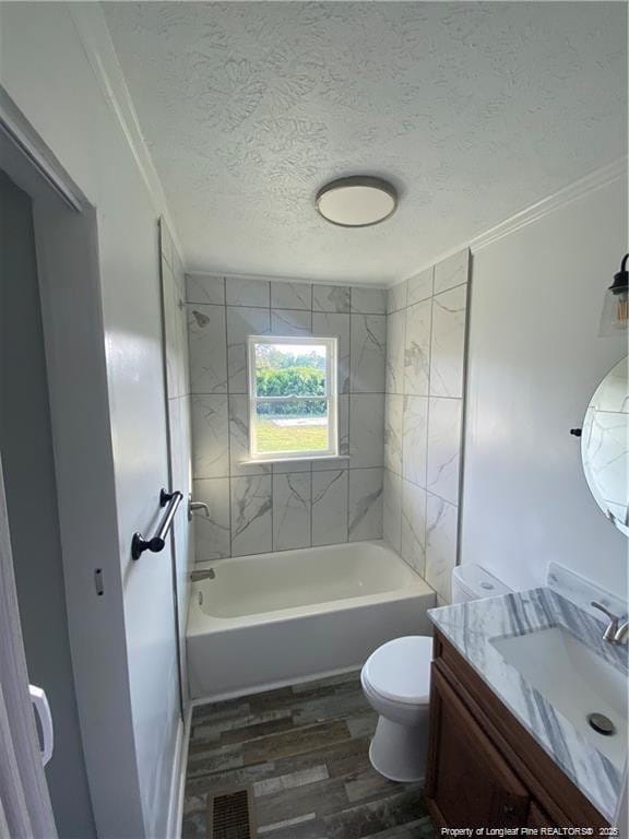 bathroom featuring visible vents, toilet, vanity, wood finished floors, and a textured ceiling