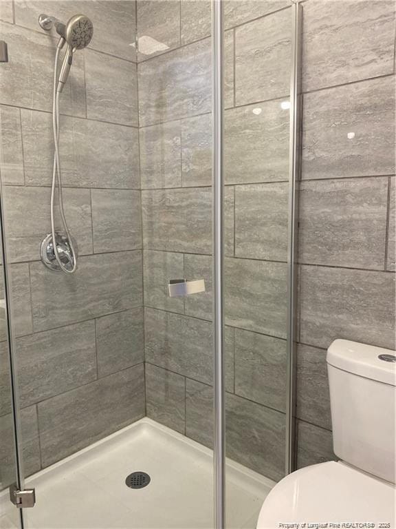 bathroom featuring a stall shower and toilet