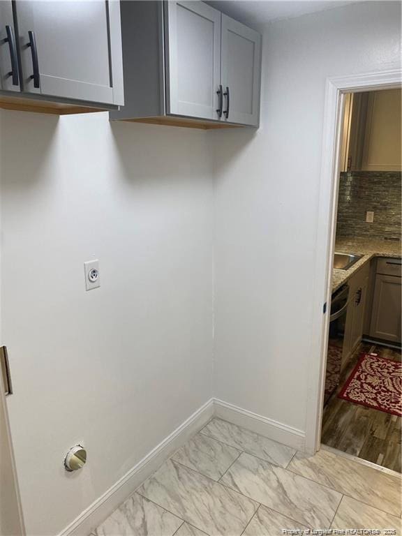 washroom with baseboards, marble finish floor, and electric dryer hookup